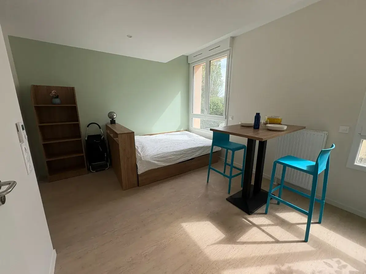 Studio meublé de la Résidence Jeunes Bayeux : lit, étagère et coin repas